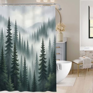 Puede incluir: Una cortina de ducha con una pintura de acuarela de una escena de bosque brumoso. El diseño presenta altos árboles de hoja perenne de color verde oscuro en una composición en capas, con una suave niebla gris en el fondo. La cortina está en un baño.