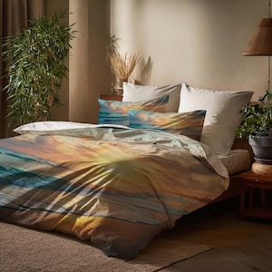 May include: Bedding set with an ocean sunset design. The duvet cover and pillowcases showcase a blend of orange, yellow, blue, and white, creating a serene aesthetic. The set includes a duvet cover and two pillowcases, perfect for a bedroom.