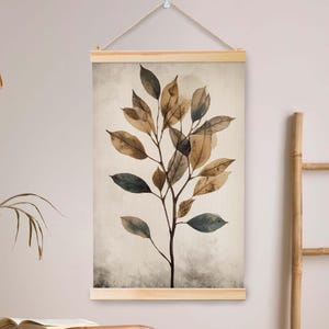 Puede incluir: Un colgante de pared botánico con una ilustración de acuarela de una planta con hojas marrones y verdes. La obra de arte se muestra sobre un fondo beige y está enmarcada por madera natural. Una pieza sencilla y elegante para la decoración del hogar.