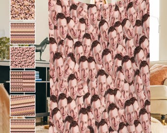 May include: A custom face blanket with 1-20 faces printed on it. The blanket is pink and white with a repeating pattern of faces. The blanket is shown being held by a person.
