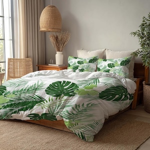 May include: White bedding set with a vibrant green tropical leaf pattern. The set includes a duvet cover and two pillowcases, creating a fresh, nature-inspired aesthetic. The bed is made of wood and is placed on a woven rug.