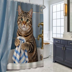 May include: A shower curtain featuring a brown tabby cat standing in a white bathtub. The cat is holding a blue and white striped towel with its front paws. The background shows blue tiled walls and a brass faucet fixture above the bathtub.