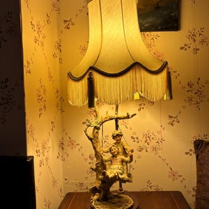 Porcelanowa lampa stołowa z figurą przedstawiającą parę z epoki wiktoriańskiej, z ozdobnym kloszem z frędzlami