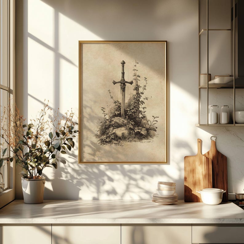 Peut inclure: Une impression encadr&eacute;e repr&eacute;sentant une &eacute;p&eacute;e dans une pierre, entour&eacute;e de verdure. L'&oelig;uvre est en tons s&eacute;pia, avec un cadre dor&eacute;. L'impression est expos&eacute;e dans une cuisine, &eacute;clair&eacute;e par la lumi&egrave;re naturelle.