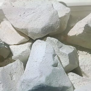 Peut inclure: Gros plan sur un tas de roches de craie blanche. Les roches sont rugueuses et ont un aspect naturel et non poli.