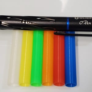 May include: A black Olight O-Pen Mini pen with a blue accent and a silver inscription. The pen is lying on top of six different colored pen refills: white, yellow, green, orange, red, and blue.