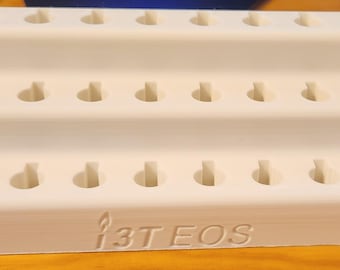May include: White plastic organizer with three tiers and 36 round holes. The organizer has the text "13T EOS" printed on the bottom.