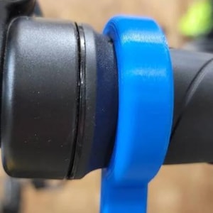 May include: A close-up of a blue handlebar grip for a bicycle.
