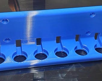May include: A blue plastic wall-mounted organizer with six round holes for storing items.