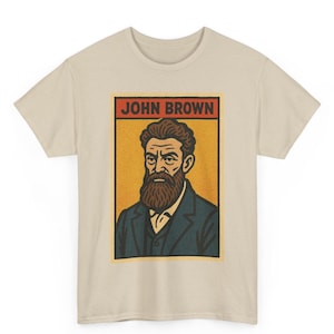 May include: A beige t-shirt featuring a rectangular graphic of John Brown. The graphic has a yellow background with a portrait of John Brown in a blue suit and a brown beard. The text "JOHN BROWN" is in red letters at the top.