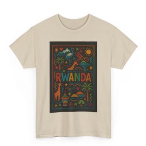Può includere: T-shirt beige con un design grafico colorato. Il design include la parola "RWANDA" in colori arcobaleno, insieme a illustrazioni di giraffe, palme e altri simboli, il tutto all'interno di una cornice nera.