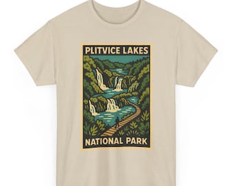 Op de afbeelding: Beige t-shirt met een afbeelding van het Nationaal Park Plitvicemeren. Het ontwerp toont watervallen, een pad en de tekst "PLITVICE LAKES NATIONAL PARK" in een rechthoekig kader. Het shirt is gemaakt van een zacht materiaal.