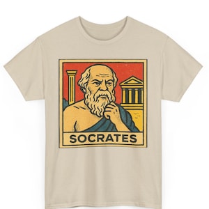 May include: Beige t-shirt featuring a graphic of Socrates in a rectangular frame. The graphic includes a portrait of Socrates, a column, and a building, with the name "SOCRATES" below.