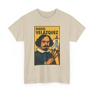 Puede incluir: Camiseta beige con un gráfico de estilo vintage de Diego Velázquez, pintor español. El gráfico incluye el retrato del artista, su nombre y una imagen de una pintura en un caballete. La camiseta tiene cuello redondo.