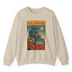 Może przedstawiać: Beżowa bluza z prostokątną grafiką. Grafika przedstawia napis "KILLDOZER" nad ilustracją niebieskiego buldożera strzelającego płomieniem. Tło jest niebieskie i czerwone.