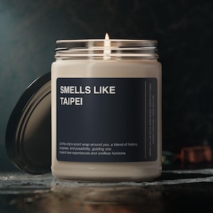 May include: A glass candle jar with a black label that reads "SMELLS LIKE TAIPEI". The label also includes the text "Let the city's scent wrap around you, a blend of history, progress, and possibility, guiding you toward new experiences and endless horizons."