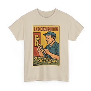 Puede incluir: Camiseta beige con un gráfico retro de un cerrajero. El diseño muestra a un hombre con camisa y gorra azules trabajando en una cerradura, con la palabra "LOCKSMITH" en rojo y varias llaves.