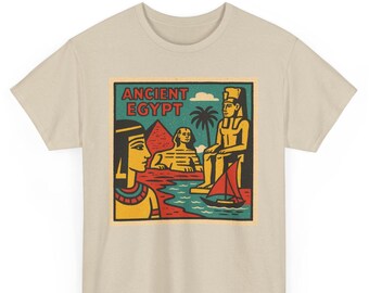 May include: Beige t-shirt featuring a colorful graphic of Ancient Egypt. The design includes a pharaoh, the Sphinx, a boat, and the text "ANCIENT EGYPT" in a rectangular frame. The artwork is in a vintage, cartoon style.
