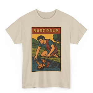 以下が含まれることがあります： ベージュ色のTシャツ。長方形のグラフィックがあり、上部に「NARCISSUS」の文字。グラフィックは、青と赤のチュニックを着た人物が水辺にひざまずき、その姿が水面に映っている様子を描いています。背景には緑の風景が描かれています。