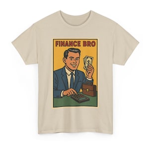 以下が含まれることがあります： ベージュ色のTシャツ。レトロスタイルのグラフィックで、スーツ姿の男性がお金とブリーフケースを持っており、「FINANCE BRO」の文字が長方形のフレームに入っています。デザインはヴィンテージコミック風です。