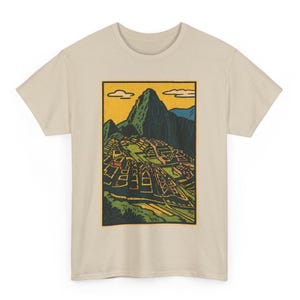 Peut inclure: T-shirt beige avec un motif rectangulaire de Machu Picchu dans un style vintage. Le motif représente la montagne et l'ancienne cité dans des tons verts, jaunes et bleus. Le t-shirt est fait d'un tissu doux et de couleur claire.