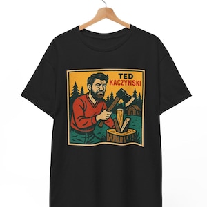 May include: Black t-shirt with a graphic of a man with a beard holding an axe and a wood block. The graphic is in a yellow, green, and brown color scheme. The text "TED KACZYNSKI" is above the graphic.