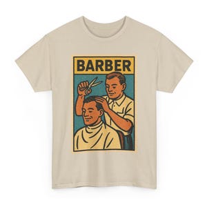 Peut inclure: T-shirt beige avec un motif rétro d'un barbier coupant les cheveux d'un client. Le motif comprend le mot "BARBER" dans un rectangle jaune et noir. Le barbier et le client sont représentés dans un style d'illustration vintage.