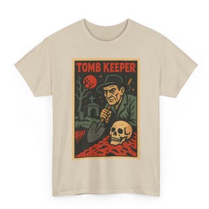 May include: Beige t-shirt featuring a vintage-style graphic. The graphic depicts a man in a hat holding a shovel, a skull, and the text "TOMB KEEPER" in red. The background includes a graveyard scene with a full moon.