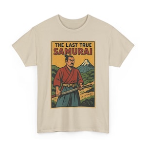 Pode incluir: Camiseta bege com um gráfico de um samurai segurando uma katana, com um fundo de montanha. O gráfico inclui o texto "THE LAST TRUE SAMURAI" em uma moldura retangular. O samurai está vestindo uma roupa vermelha e azul.