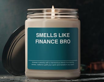 May include: A white candle in a glass jar with a teal label that reads "SMELLS LIKE FINANCE BRO". The label also includes the text "Immerse in serenity with a harmonious blend of enchanting aromas, crafted to uplift your spirit and transform any space."