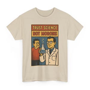 May include: Beige t-shirt with a retro-style graphic. The graphic features a scientist holding a flask, with the text "TRUST SCIENCE NOT MORONS" above the image of the scientist and another person.