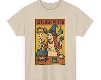 Könnte beinhalten: Beiges T-Shirt mit einem Retro-Design einer Hexe, die in einem Kessel kocht. Die Hexe trägt einen blauen Hut und ein rotes Kleid, mit dem Text "KITCHEN WITCH" darüber. Ein lustiges Design für Koch- und Halloween-Fans.