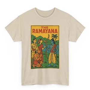 May include: Beige t-shirt featuring a rectangular graphic with the text "THE RAMAYANA" in red letters. The graphic depicts a scene with several figures, including a blue-skinned man with a bow and arrow, and other figures in traditional clothing.