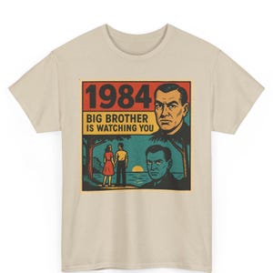 May include: A beige t-shirt with a vintage-style graphic print featuring the text "1984 Big Brother is Watching You". The graphic depicts a man with a stern expression, a couple standing on a beach, and a palm tree.