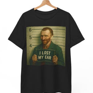 Puede incluir: Camiseta negra con una foto de Vincent van Gogh en una ficha policial con el texto "Perdí mi oreja".