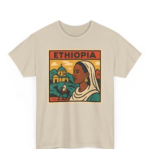 Könnte beinhalten: Beiges T-Shirt mit einem Vintage-Grafikdesign. Das Design zeigt das Profil einer Frau, eine Kirche und einen Kamelreiter, mit dem Wort "ETHIOPIA" in einem roten Feld. Die Ästhetik erinnert an Reiseplakate.