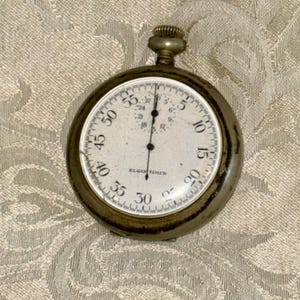 Pode incluir: Uma placa de madeira artesanal com a palavra "Welcome" em uma fonte lúdica. A placa branca tem um acabamento desgastado e um pequeno coração decorativo. Para uso interno ou externo.