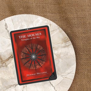 Puede incluir: Una tarjeta roja y negra con el texto "THE HOUSES Temples of the Sky" y el nombre del autor, Deborah Houlding. La tarjeta presenta un diseño de estrella y está colocada sobre una superficie similar al mármol con un fondo de arpillera.