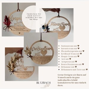 May include: Wooden circular signs with laser-cut text and decorative dried flowers. The signs feature phrases like "Intensivteam mit" and "Krei&szlig;saalteam mit." Each sign has a dark brown hanging cord. The signs are for sale.