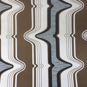 Op de afbeelding: Abstracte behang met een golvend patroon in bruin, wit en grijs.