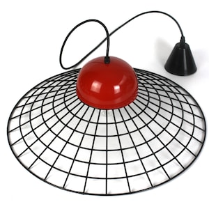 May include: A modern pendant light fixture featuring a red, spherical top and a black, cone-shaped element. The light has a large, circular, black wire mesh shade. The fixture hangs from a black cord.