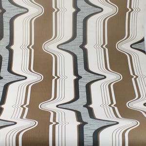 Op de afbeelding: Abstracte behang met golvende bruine, zwarte en grijze strepen op een witte achtergrond.