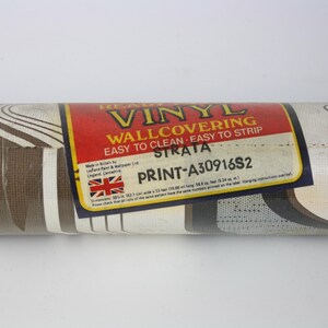 Op de afbeelding: Een rol bruin en wit vinyl behang met een golvend patroon. Het label vermeldt "Heavy Vinyl Wallcovering Easy to Clean - Easy to Strip Strata Print-A30916S2"