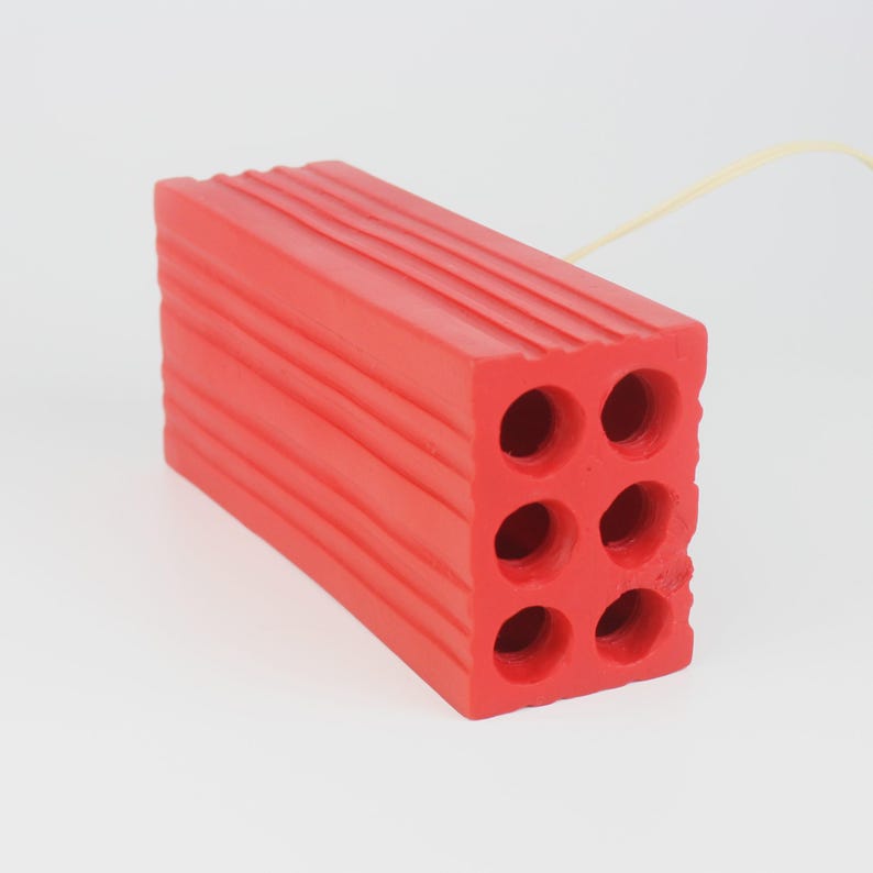 Pu&ograve; includere: Un mattone rettangolare rosso brillante con sei fori circolari e scanalature orizzontali sulla parte superiore. Il mattone &egrave; fatto di un materiale solido ed &egrave; posto su uno sfondo bianco. &Egrave; un materiale da costruzione.