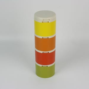 May include: A colorful, stackable container with a light beige lid. The container is composed of four sections in yellow, orange, red, and green, separated by white bands. The cylindrical design is ideal for storing small items.