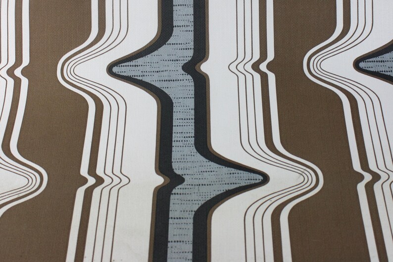Op de afbeelding: Abstracte behang met bruine en witte strepen en een golvend ontwerp in grijs en zwart.