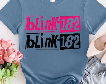 May include: A blue t-shirt with the words "blink 182" printed in pink and black.