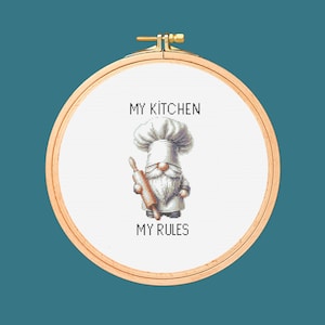 Könnte beinhalten: Kreuzstich-Stickerei in einem Holzreifen. Das Design zeigt einen Koch-Zwerg mit einer Teigrolle, mit dem Text "MY KITCHEN MY RULES" über und unter dem Zwerg. Der Hintergrund ist türkis.