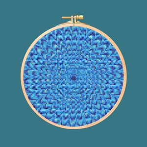 May include: A blue and teal circular cross-stitch pattern in a wooden embroidery hoop.