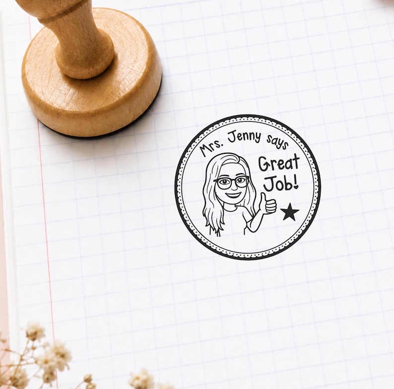 K&ouml;nnte beinhalten: Runder Holzstempel mit einem Cartoon einer Frau mit Brille und dem Text "Mrs. Jenny says Great Job!". Der Stempel ist schwarz-wei&szlig; und hat einen gepunkteten Rand.